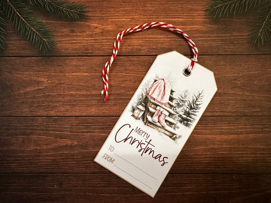 handmade rustic merry christmas gift tag with red and white twine on wooden background